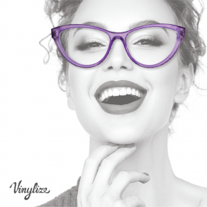 Black-and-white photo of a laughing woman wearing translucent purple cat-eye glasses, Vinylize